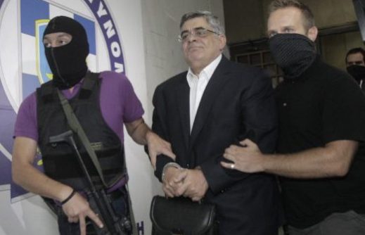 Far-right Golden Dawn party leader Mihaloliakos is escorted by anti-terrorism police officers as he leaves the Greek police headquarters in Athens