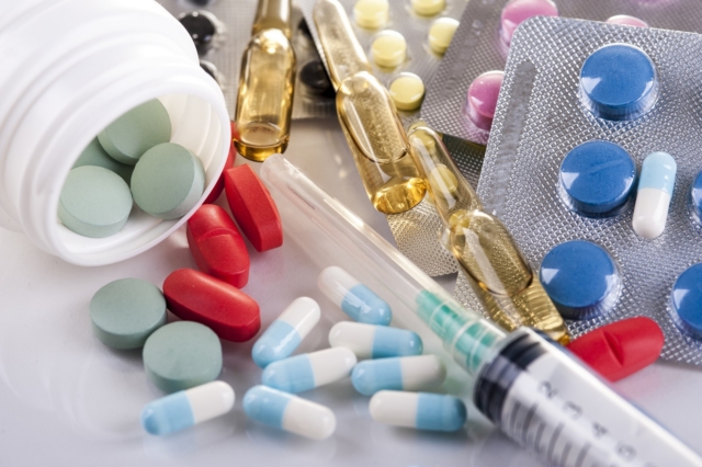 Syringe, blisters with colorful pills and capsules